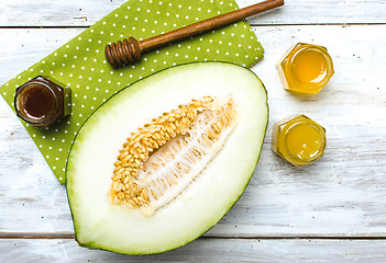 Image showing Healthy melon with honey on napkin and rustic board