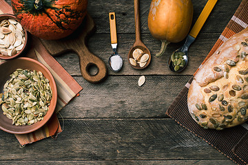 Image showing Rustic style pumpkins with bread and seeds on wood