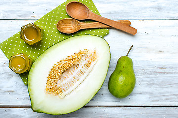 Image showing Healthy cut melon pear and honey on white board