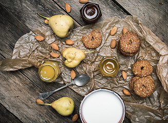 Image showing Tasty Pears almonds Cookies and milk on rustic wood