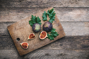 Image showing Cut Figs on chopping board and wood table