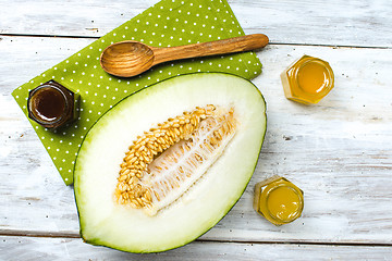 Image showing Melon with honey on napkin and rustic board