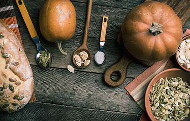 Image showing Rustic pumpkins and bread with seeds on wood