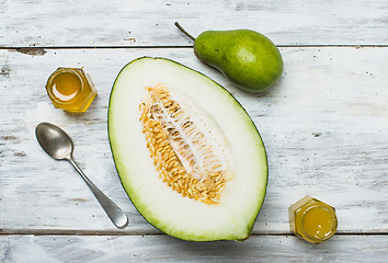 Image showing Healthy pear with melon and honey on rustic board