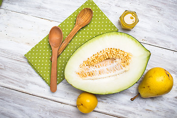 Image showing Half cut melon with honey and pears in rustic style