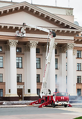 Image showing Builders paint building facade by fire truck