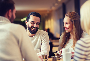 Image showing happy friends meeting and drinking tea or coffee