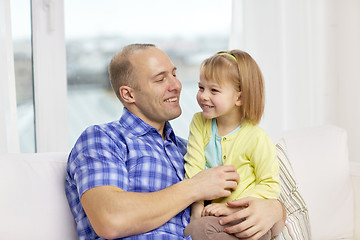 Image showing happy father and daughter sitting on sofa at home