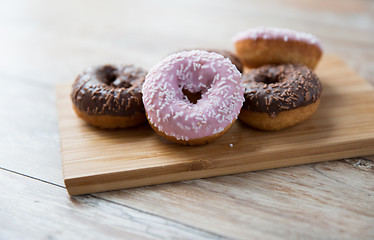 Image showing close up of glazed donuts pile on wooden table