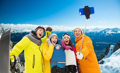 Image showing happy friends with snowboards and smartphone