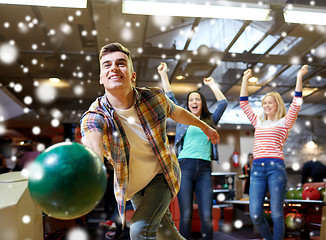 Image showing happy young man throwing ball in bowling club