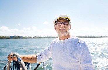 Image showing senior man at helm on boat or yacht sailing in sea