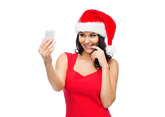 Image showing woman in santa hat taking selfie by smartphone