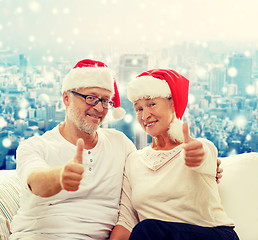 Image showing happy senior couple in santa helper hats