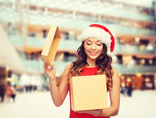 Image showing smiling woman in santa helper hat with gift box