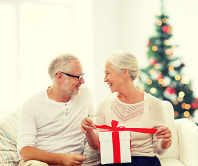 Image showing happy senior couple with gift box at home