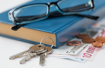 Image showing close up of book, money, glasses and keys on table