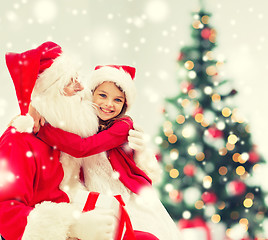 Image showing smiling girl with santa claus and gift at home