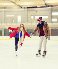 Image showing happy couple holding hands on skating rink