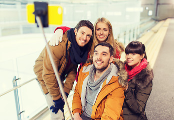 Image showing happy friends with smartphone on skating rink