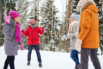 Image showing happy friends playing snowball in winter forest