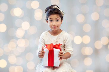 Image showing happy little girl with present over lights