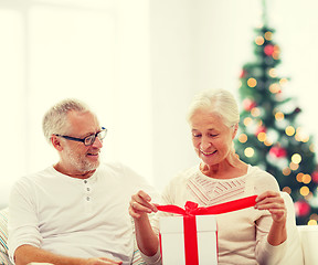 Image showing happy senior couple with gift box at home