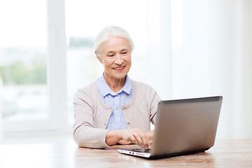 Image showing happy senior woman with laptop at home