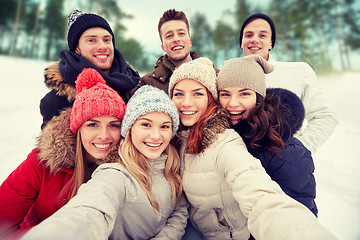 Image showing group of smiling friends taking selfie outdoors