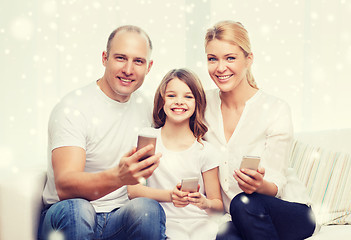 Image showing happy family with smartphones at home