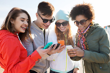 Image showing smiling friends with smartphones