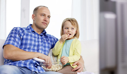 Image showing happy family with popcorn watching tv at home