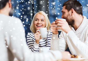 Image showing happy friends meeting and drinking tea or coffee