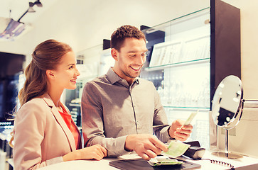 Image showing happy couple paying for purchase in store