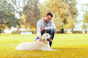 Image showing happy man with labrador dog in autumn city park