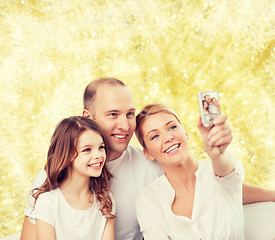 Image showing happy family with camera at home