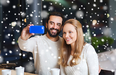 Image showing happy couple with smartphone  and coffee at cafe