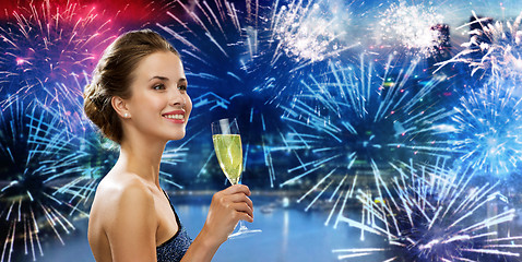 Image showing happy woman drinking champagne wine over firework