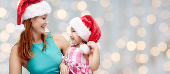 Image showing happy mother and little girl in santa hats