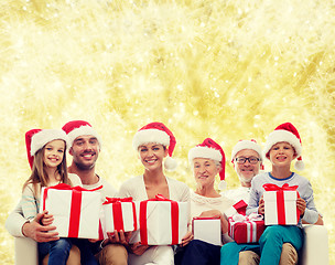 Image showing happy family in santa helper hats with gift boxes