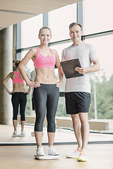 Image showing smiling man and woman with scales in gym