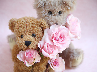 Image showing two teddy bears holding roses