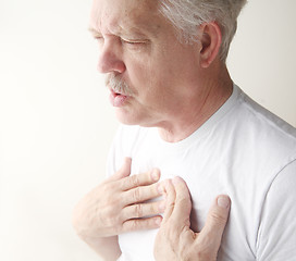 Image showing Man exhales with hands on chest.