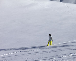 Image showing Snowboarder downhill on off piste slope with newly-fallen snow