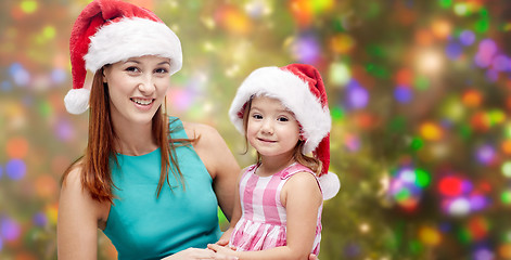 Image showing happy mother and little girl in santa hats
