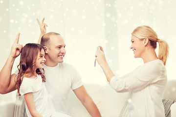 Image showing happy family with camera taking picture at home