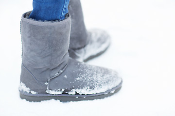 Image showing close up of woman legs wearing warm boots on snow