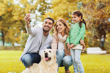 Image showing happy family with dog taking selfie by smartphone