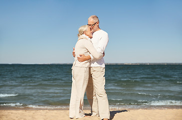 Image showing happy senior couple hugging on summer beach