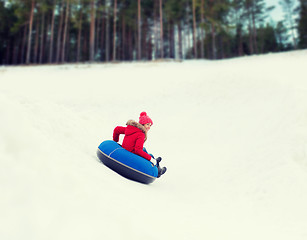 Image showing happy teenage girl sliding down on snow tube